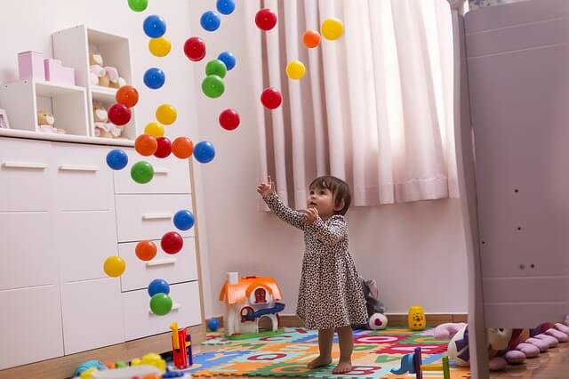 Toddler girl playing with balloons